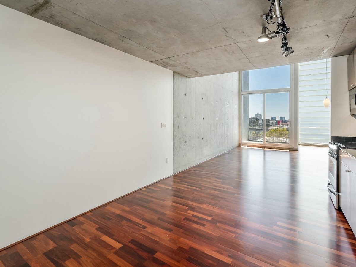 855 Folsom #711 – loft living room with concrete walls, hardwood floors and city views